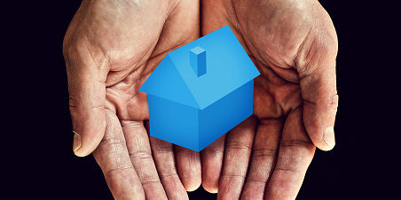 Blue house in cupped hands