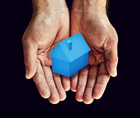 Blue house in cupped hands
