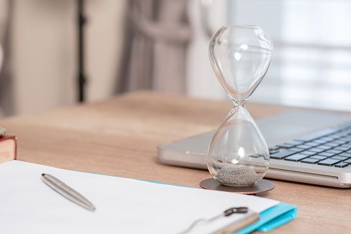Deadline and time is money concept with hourglass