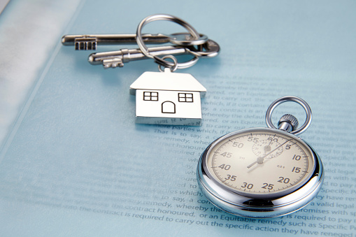 Close-Up Of House Key And Pocket Watch On Document
