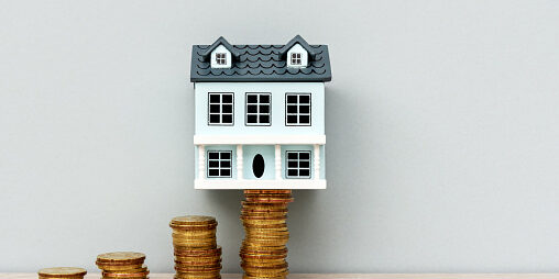 House Model on Top of Stack of Coins