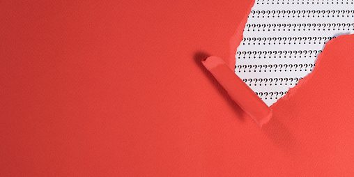 Red Paper Teared Revealing Question Mark On White Paper.