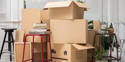 Cardboard boxes on the floor in new home moving tips
