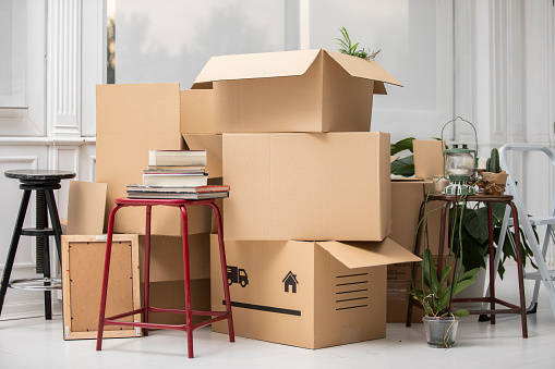Cardboard boxes on the floor in new home moving tips